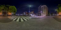 a picture of an intersection and some buildings by a street light and trees at night