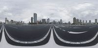 empty roadway and buildings in front of cityscape and cloudy sky in panorama style