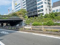 a motorcyclist riding past an overpass in the middle of a city