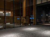 an open door at the lobby of a modern building with glass doors on either side