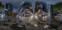 an intersection shows the curved buildings as seen from a fish eye view point at night