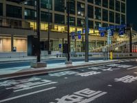 an image of outside of the night time building with the lights turned on and the streets empty