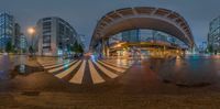 a night view of a pedestrian crossing intersection in an illuminated city streetscape with a curved pedestrian crossing