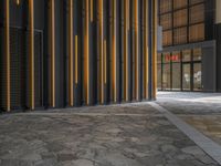 a walkway leading up to a wooden wall next to a cement area with floor tiles