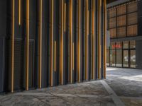 a walkway leading up to a wooden wall next to a cement area with floor tiles