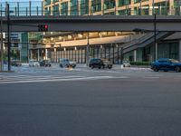 an empty road with a street sign at the curb in front of an office building