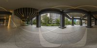 a panoramic picture shows several courtyard spaces with an arched building and curved columns