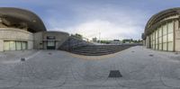 several steps and a circular concrete building have been shot with a fisheye lens,