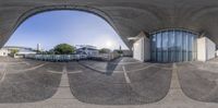 the fish eye view is of a large building near a pool and beach area near water