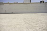 the top of a building that has a clock on it and there is gravel floor