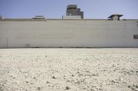 the top of a building that has a clock on it and there is gravel floor