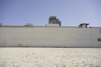 the top of a building that has a clock on it and there is gravel floor
