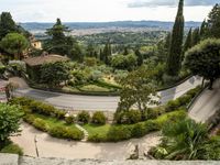 a curved road on the edge of an olive groves and garden area in italy's umberica