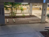 there is an empty parking garage under a building that features columns and steps, but with a bicycle leaning on a wall