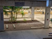 there is an empty parking garage under a building that features columns and steps, but with a bicycle leaning on a wall