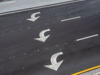 an aerial photo shows three directions on the sidewalk with arrows pointing up and down, and with grass, in front of the road