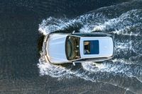 top down shot of a car driving on water with waves running in the air around