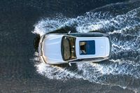 top down shot of a car driving on water with waves running in the air around