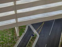 a view of a road and an overpass with traffic passing through it by buildings