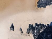 an aerial view of a mountain range covered in snow and rocks with shadows coming from the top of it