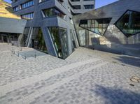 an outside view of an office building with some windows and a bench area inside it