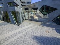 an outside view of an office building with some windows and a bench area inside it