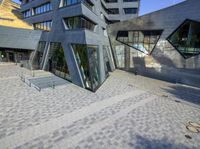 an outside view of an office building with some windows and a bench area inside it