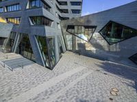 an outside view of an office building with some windows and a bench area inside it