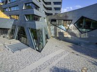 an outside view of an office building with some windows and a bench area inside it