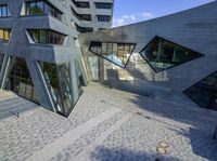 an outside view of an office building with some windows and a bench area inside it