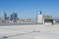 an empty parking lot with a view of a city in the background is shown from the top of a building