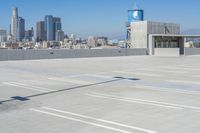 an empty parking lot with a view of a city in the background is shown from the top of a building