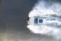 the top view of a small boat is sailing across the water with white spray coming out of the boat