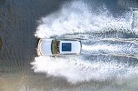 the top view of a small boat is sailing across the water with white spray coming out of the boat