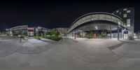 many people at the entrance of an airport at night time in this mirror image, taken with fisheye camera