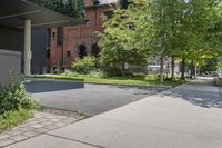 the large building is very tall and the roof is gray and there is green bushes