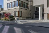 this is an image of a large building on a street corner in the city, with plants growing near it