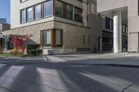 this is an image of a large building on a street corner in the city, with plants growing near it