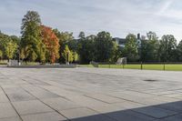 a man riding a skateboard down the side of a brick road next to trees