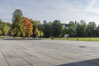 a man riding a skateboard down the side of a brick road next to trees