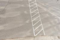 white markings on a sidewalk next to a street sign with a pedestrian crossing in the background