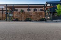 a wooden awning and a building with flowers in front of it on an empty street