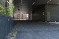 this walkway has a walkway that is surrounded by tall buildings and trees it leads to an atrium