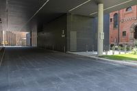 this walkway has a walkway that is surrounded by tall buildings and trees it leads to an atrium