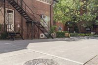 a fire hydrant on a street with stairs going up behind it, near an old brick building