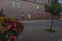 there is a clock tower that has been decorated by flowers in front of it and an apartment in the background