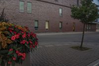 there is a clock tower that has been decorated by flowers in front of it and an apartment in the background