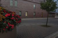 there is a clock tower that has been decorated by flowers in front of it and an apartment in the background