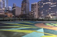 a parking lot with buildings in the background and yellow and green painted designs in the center