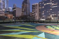 a parking lot with buildings in the background and yellow and green painted designs in the center